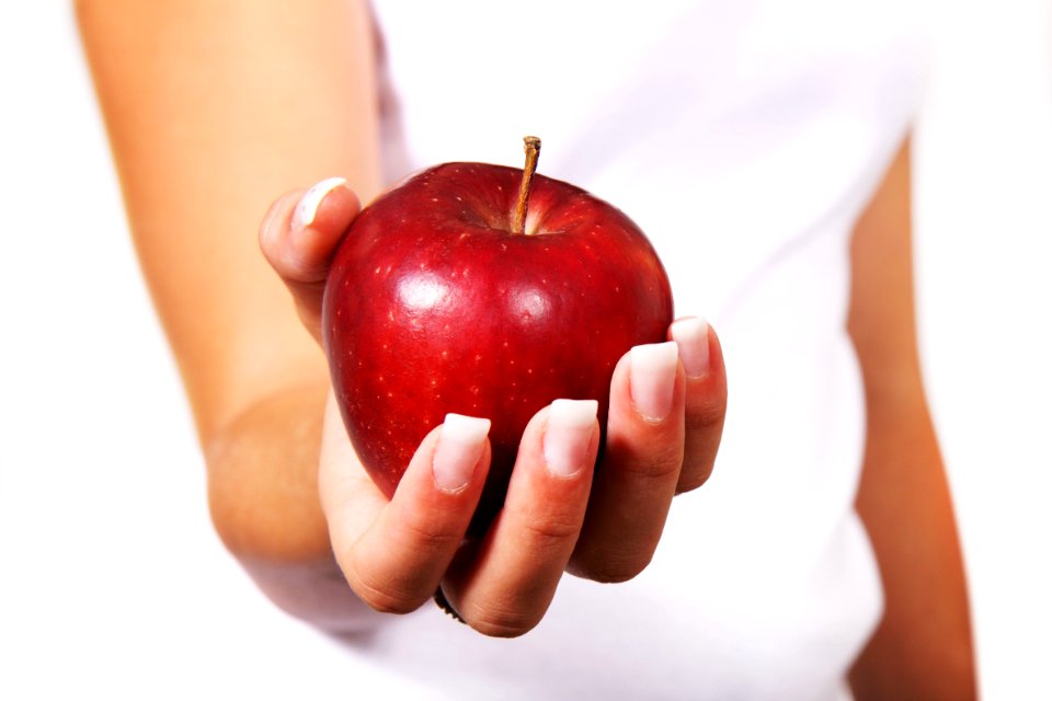 Person In White Shirt Holding Red Apple