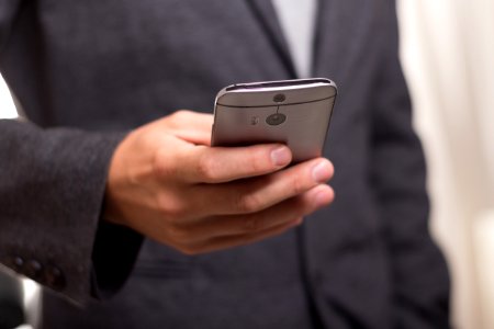 Man Wearing Black Suit Jacket Holding Gray Htc Android Smartphone