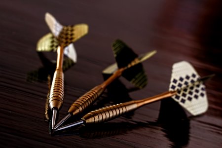 Brass Gold Darts On Brown Table photo