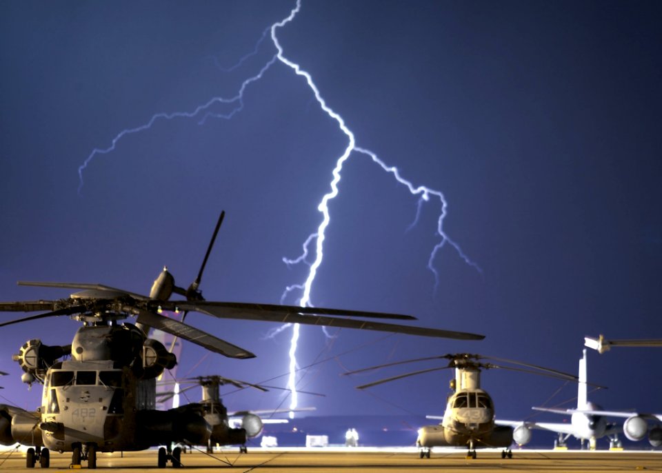 Lightning Near Grey Helicopter During Daytime