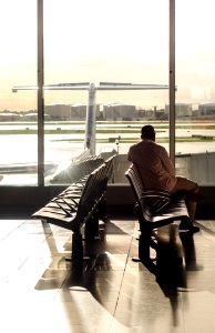 Man In Pink Sport Shirt Sitting On Brown Chair Beside Glass Window photo