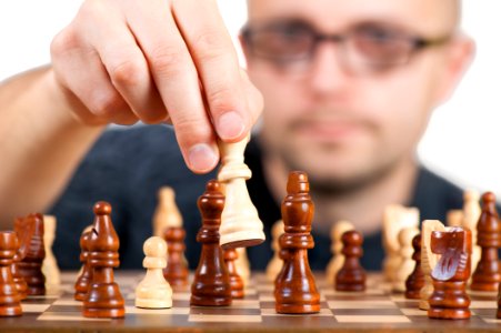 Man Holding Chess Piece