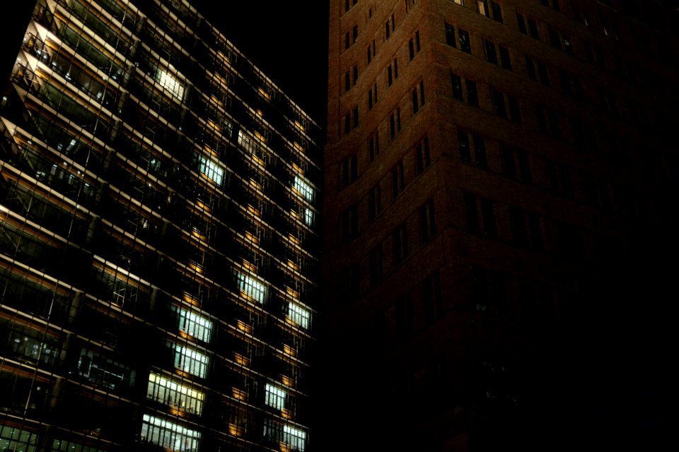 Brown Concrete Building Beside Black Concrete Building During Night Time photo