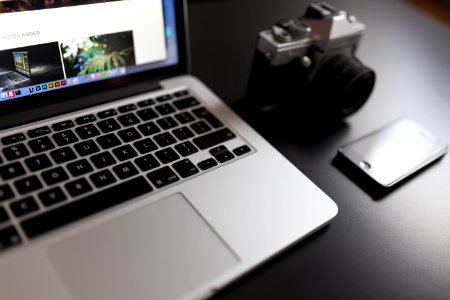 Silver Laptop Computer Beside Of White And Black Camera And Black Iphone photo