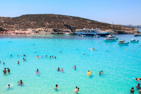 Swimmers In Blue Coastal Waters Of Malta