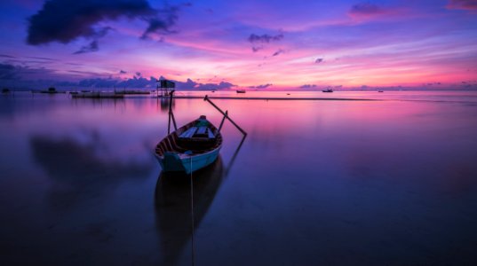 Wooden Rowboat In Still Waters At Sunset photo