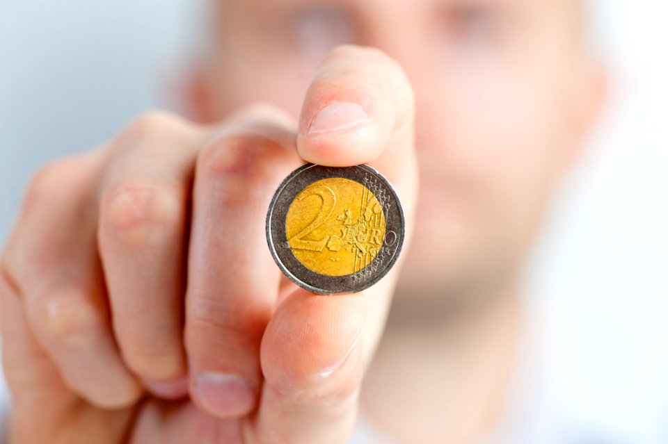 Person Holding A Gold And Silver Round Coin