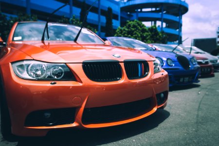 Orange Bmw Car Beside Blue Bugatti Car photo