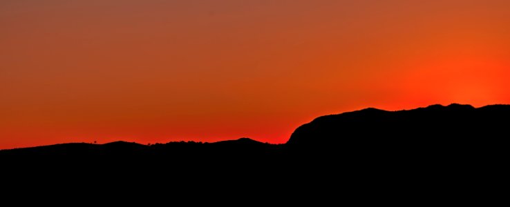 Black Mountain Under Brown Sky During Sunset photo