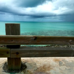 Brown Wooden Fence Near Blue Ocean Water Under White Cloudy Sky During Daytime photo