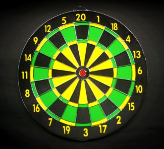 Green Yellow And Black Round Dart Board With Black Background photo