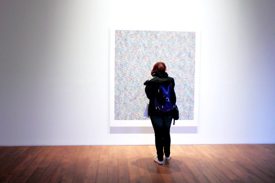 Woman Standing Infront Of A Wall Mount Painting