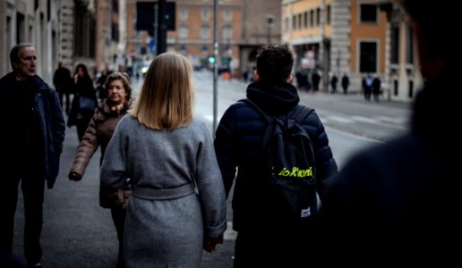 Couple Holding Hands While Walking On The Street photo