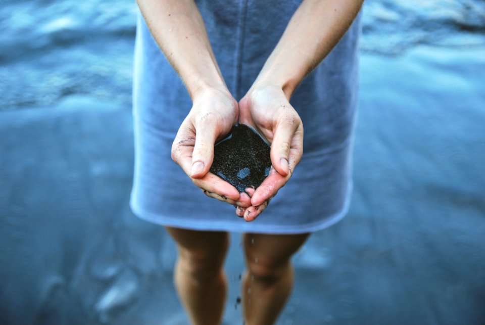 Woman Holding Sand At Beach
