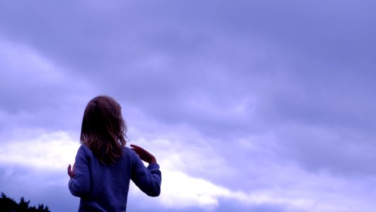 Woman In Blue Sweater Facing In Blue Clear Sky