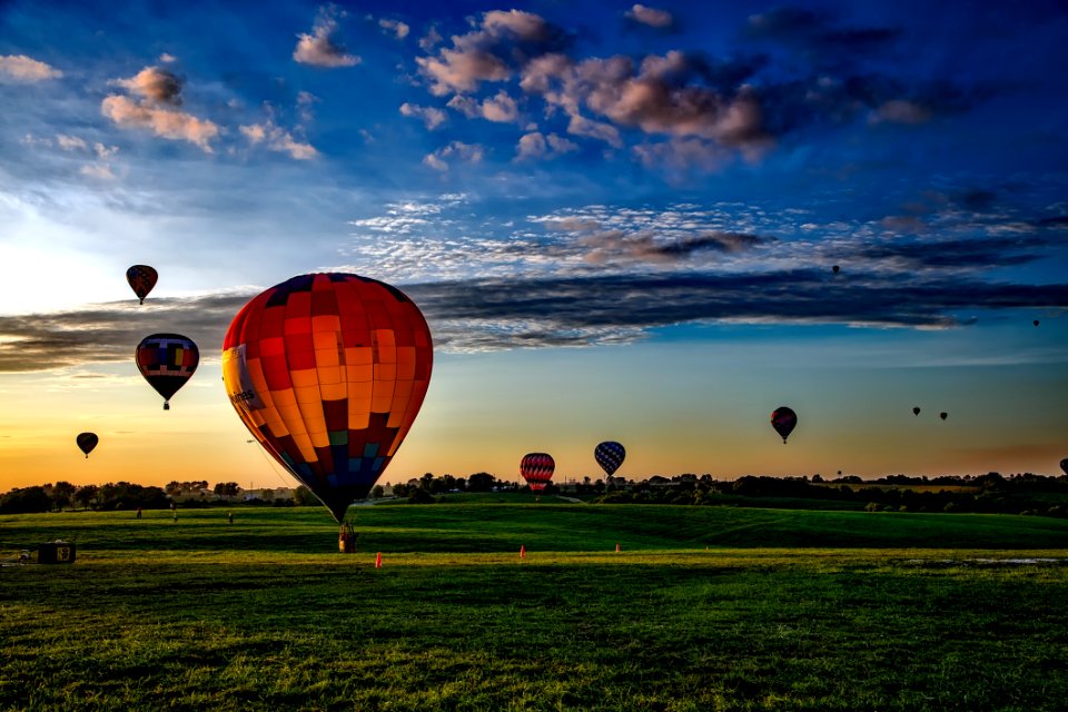 Colorful Hot Air Balloons In Field At Sunset