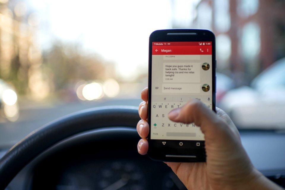 Person Sitting Inside Car With Black Android Smartphone Turned On