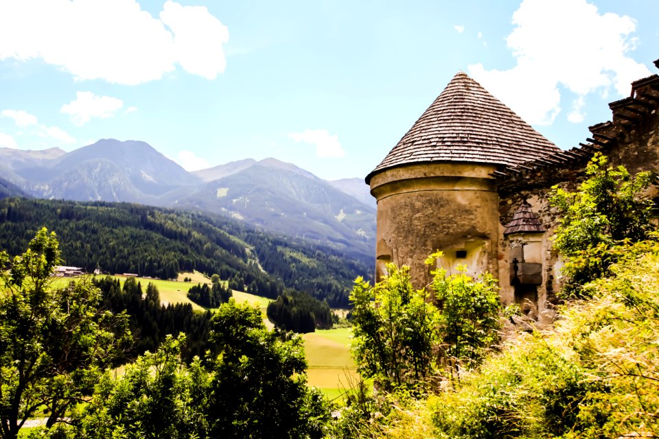 Brown Concrete House Beside Green Tree And Far Mountain On Daytime photo