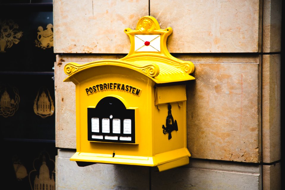 Yellow Postbriefkasten Floating Mailbox On Brown Concrete Wall