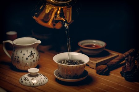 Gold Kettle Pouring Hot Water On Cup Of Tea photo