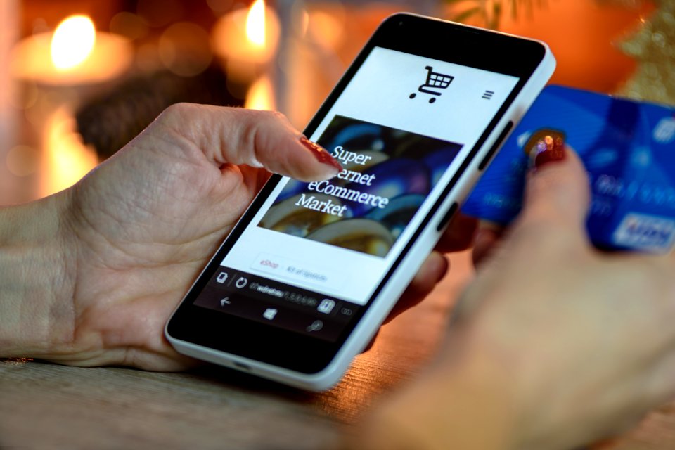 Person Using Black And White Smartphone And Holding Blue Card photo