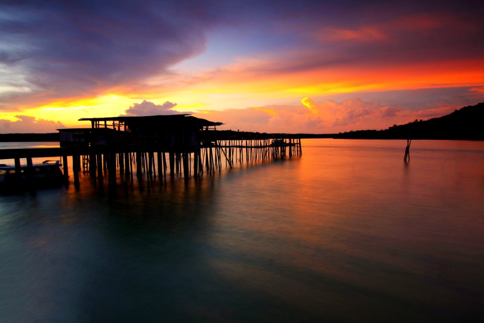 Silhouette Of Wooden House Above Sea During Sunset photo