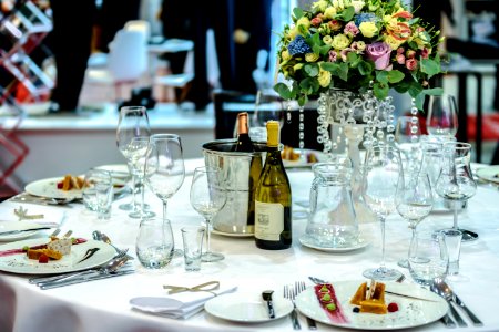 White Labeled Bottle Near Clear Glass Wine Bottle On White Round Table