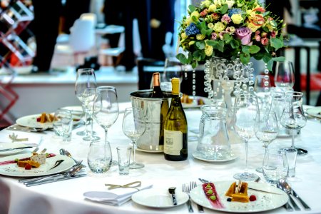 White Labeled Bottle Near Clear Glass Wine Bottle On White Round Table photo