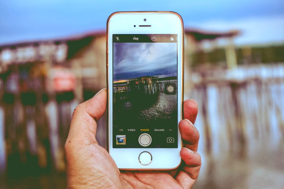 Picture Holding Iphone Taking Photo On House On Beach
