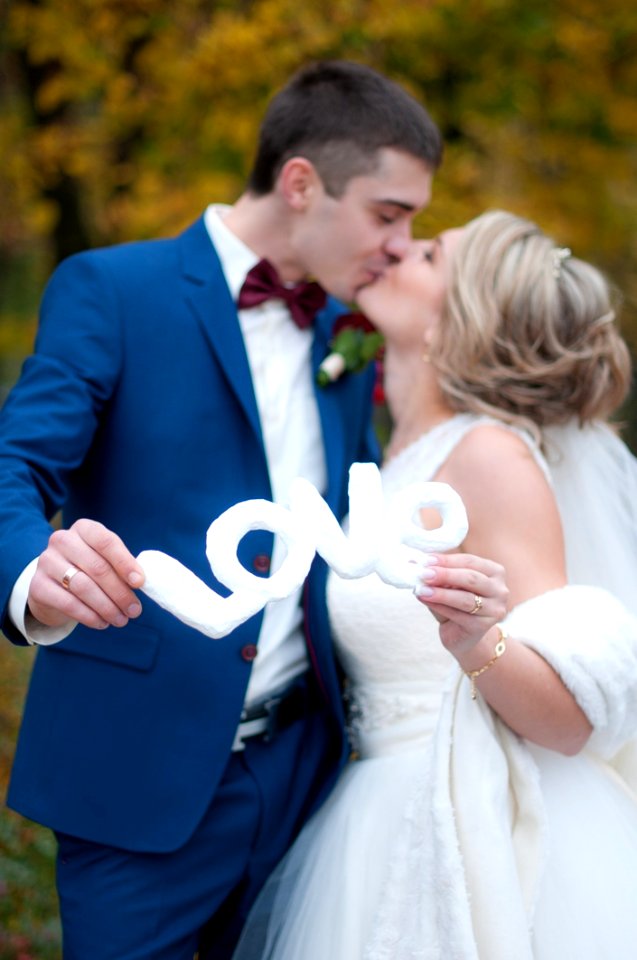 Newly Wed Couple Kissed Each Other While Holding Love Cutout