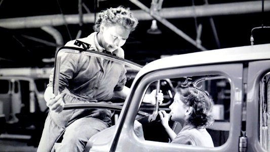 Man Carrying Car Windshield With Woman Inside A Car