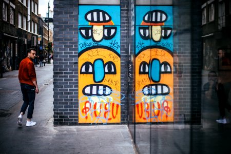 Person Wearing A Red Dress Shirt Walking Near A Wall Graffiti photo