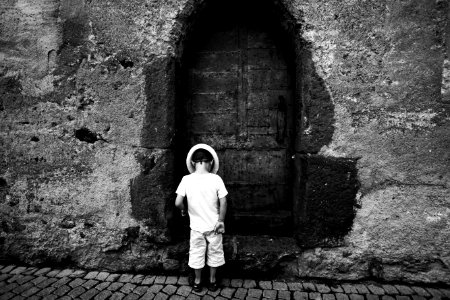 Grayscale Photo Of Toddler Standing And Wearing Hat On The Ground photo