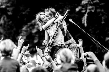 Grayscale Photo Of A Woman Kissing A Man Playing Guitar photo
