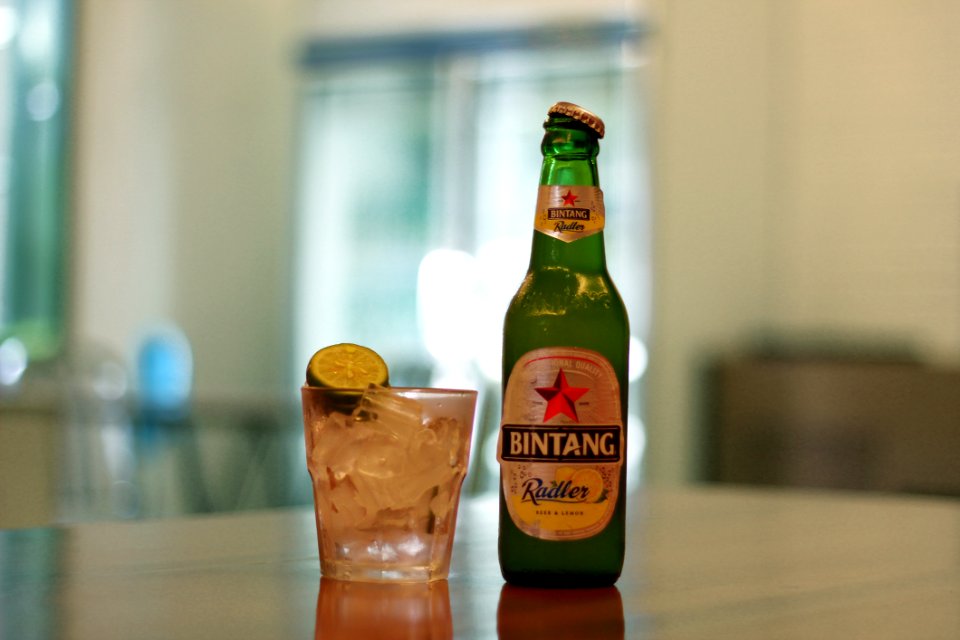 Bintang Green Glass Bottle Beside Clear Shot Glass photo