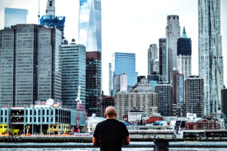 Man In Black T Shirt In Front On City Skyline During Daytime photo