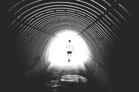 Grayscale Photo Of Man Walking In Hole photo