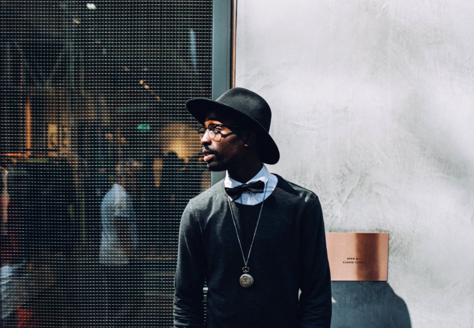 Man Wearing Black Hat A Bow And A Sweat Shirt On A Backstage photo