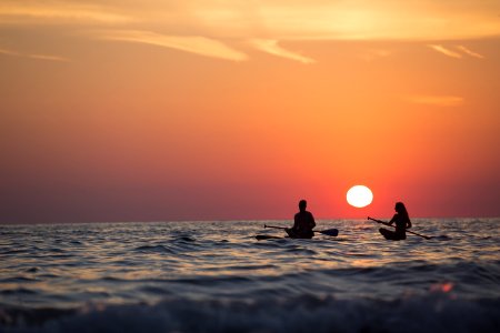 Man And Woman Boat Rowing In Sea During Golden Hour photo
