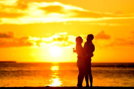 Couple Standing In The Seashore Hugging Each Other During Sunset photo