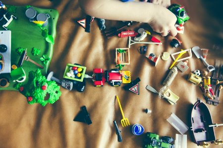 Green Rectangular Toy Gray Boat Toy Gray Shovel Toy And Green Car Toy On Top Of Brown Leather Surface photo