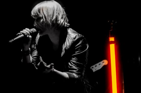 Rock Band Lead Singer Wearing Black Jacket And Wireless Microphone photo