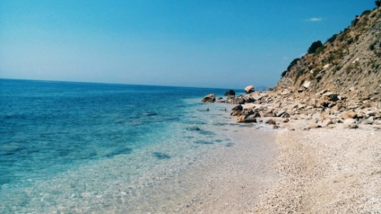 Grey Rock Formation Near Blue Beach During Daytime