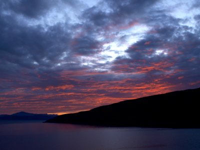 Landscape Photography Of Black Rocky Formation With Orange Horizon Under Blue Clouds photo