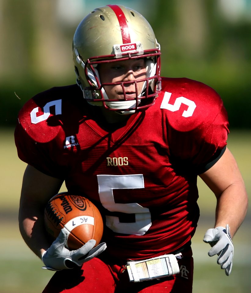 Man In Red And White Roos 5 Football Jersey Playing Football
