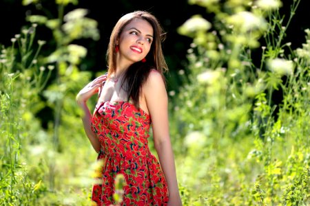 Smiling Woman In Pink Black And Green Floral Tube Dress Near Green Leaf Plants During Daytime