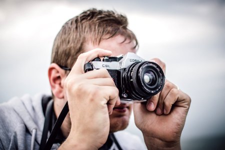 Man Holding Black Silver Bridge Camera Taking Photo During Daytime photo