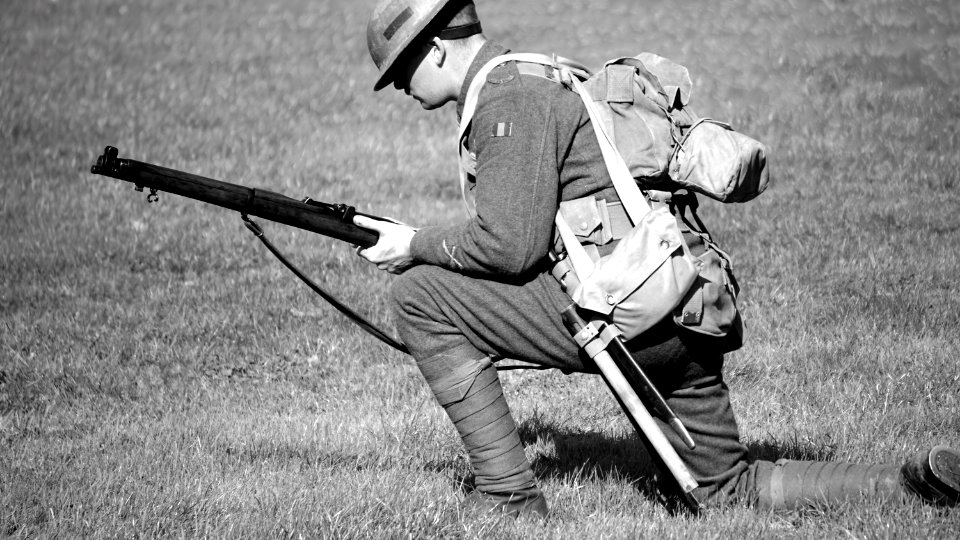 Man In Soldier Suit Holding Gun Knees Down In The Ground
