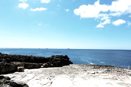 Piled Rocks Near Blue Sea Under Teal White Sky At Daytime photo