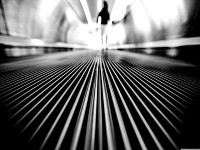 Greyscale Photography Of Man Walking On Tunnel photo